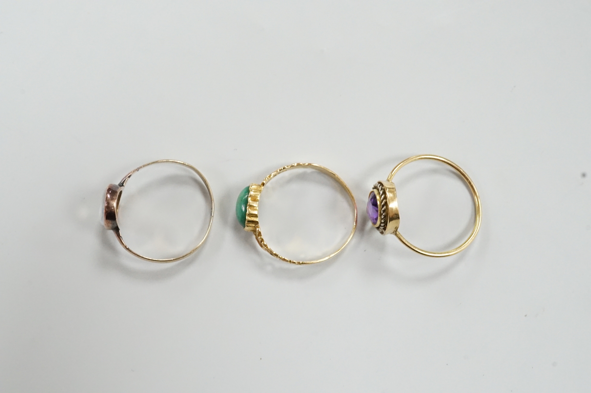 Three assorted yellow metal and gem set rings, gross weight 4.1 grams.